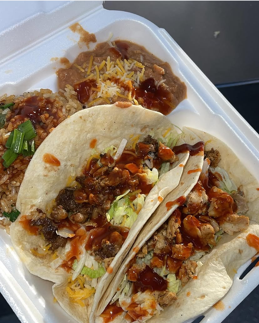Three loaded tacos with rice and beans