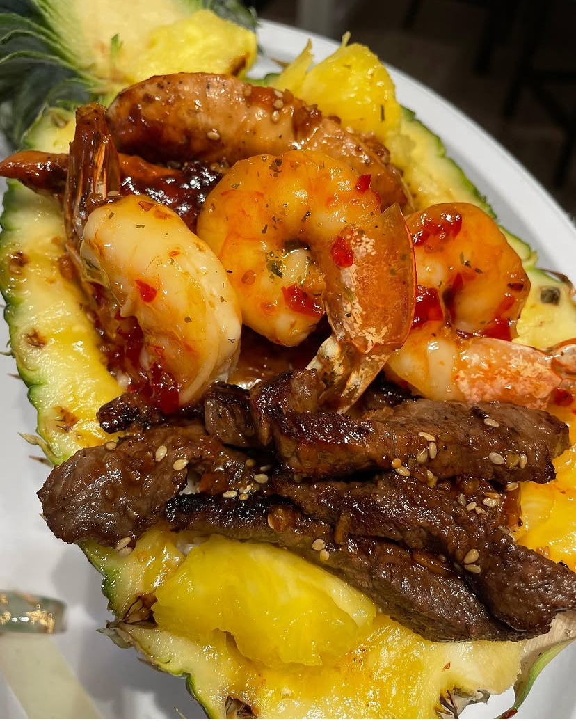 Glazed shrimp and steak served in a pineapple