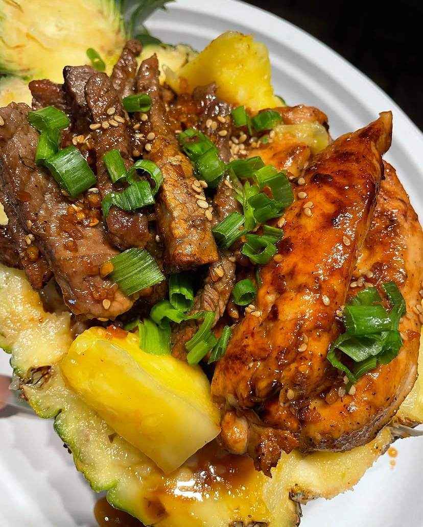 Glazed chicken and steak served in a pineapple